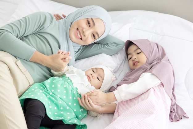 Bebê e mãe em casa na cama, família amorosa e feliz