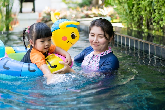 bebê e mãe jogando água na piscina