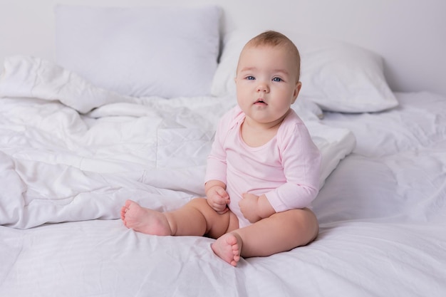 Bebê em uma roupa rosa está sentado no chão vista superior espaço para texto foto de alta qualidade