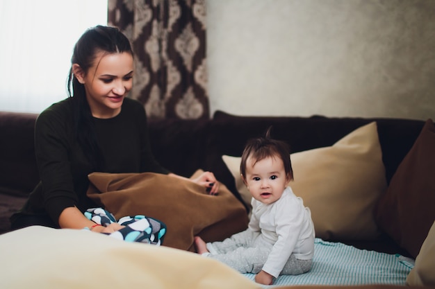 Bebê engraçado com mãe em casa.