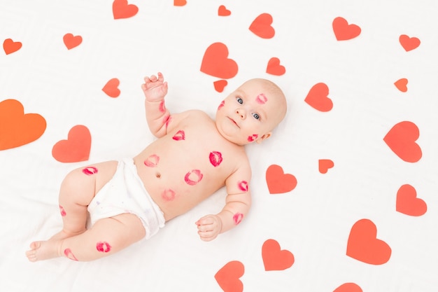 Foto bebê entre corações e com beijos de batom vermelho, conceito de amor e dia dos namorados