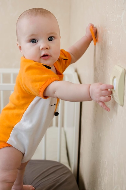 Foto bebé escalando en una pared con un interruptor