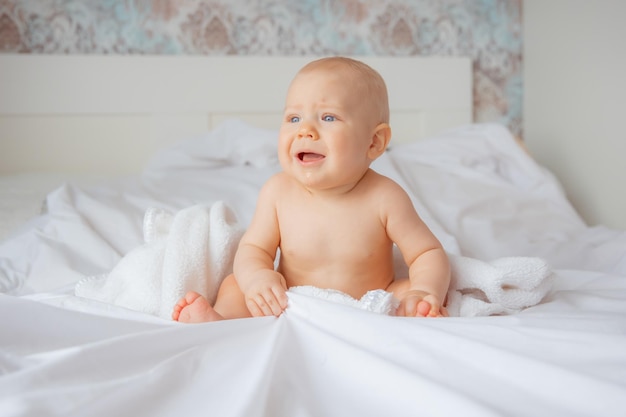 El bebé está durmiendo en el dormitorio en una cama cubierta con una sábana blanca.