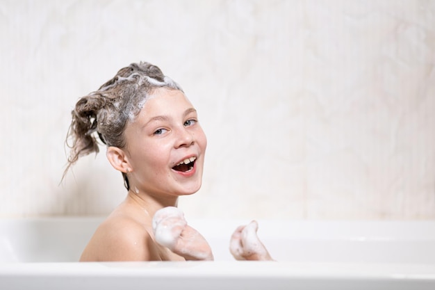 Bebé feliz bañándose con espuma en la cabeza