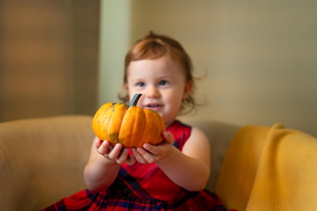 Foto bebé feliz con una calabaza para la casa de halloween