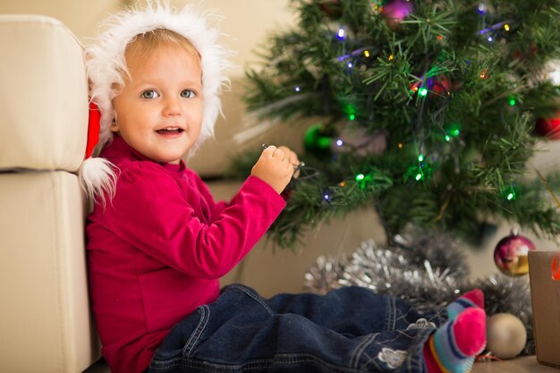 Bebé feliz cerca del árbol de Navidad