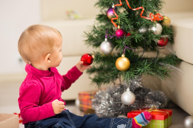 Bebé feliz cerca del árbol de Navidad