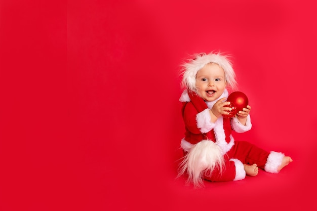 Bebê feliz com fantasia de Papai Noel sentado