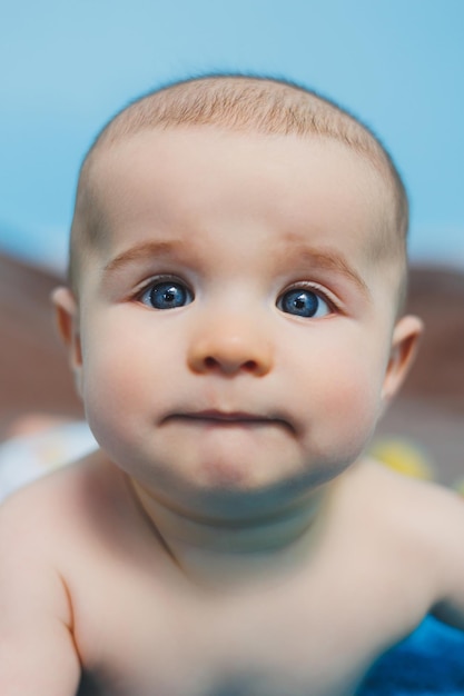 Un bebé feliz de cuatro meses yace sobre una manta tejida Retrato de bebé niño sosteniendo su cabeza