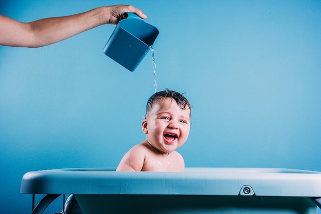 Bebê feliz e rindo tomando banho Criança sorridente no banheiro