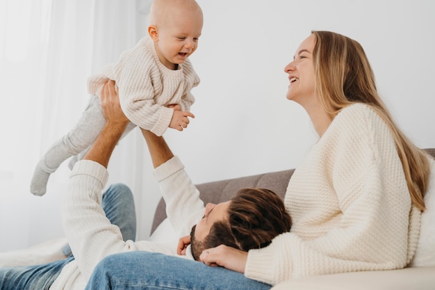 Bebé feliz con madre y padre en casa