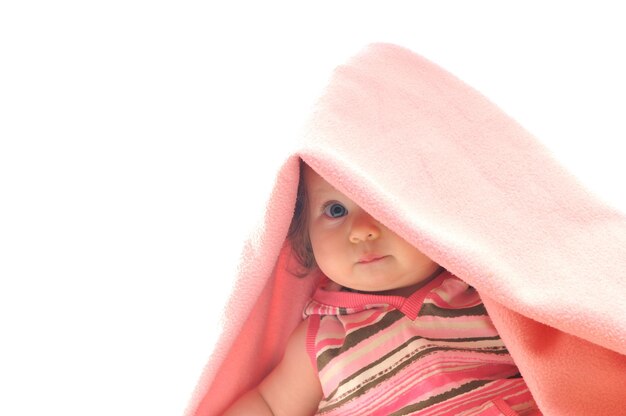 Foto bebé feliz bajo una manta aislado en blanco