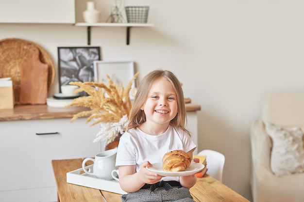 Bebê feliz. Menina na cozinha. Dia das crianças e mães. Bom dia e conceito de café da manhã.