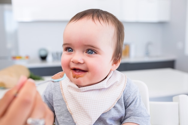 Bebé feliz siendo alimentado por la madre