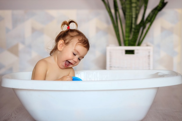 Bebê feliz tomando banho no banheiro