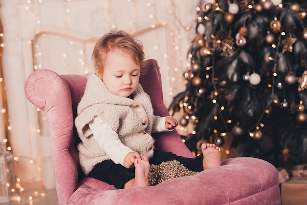 Bebé fofo brincando com as decorações de Natal