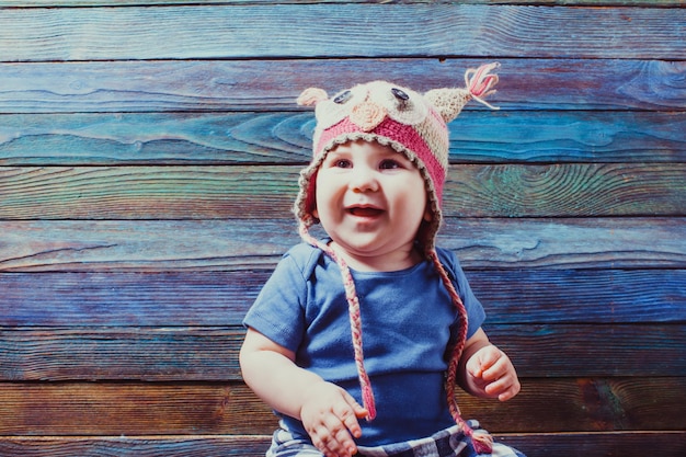 Bebê fofo com chapéu engraçado de animal posando no estúdio