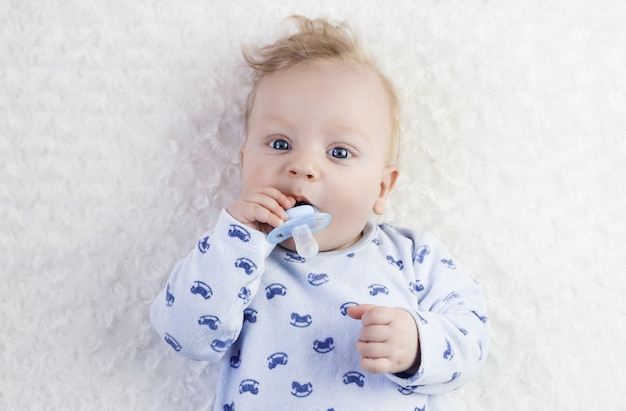 Foto bebê fofo de pijama azul com chupeta