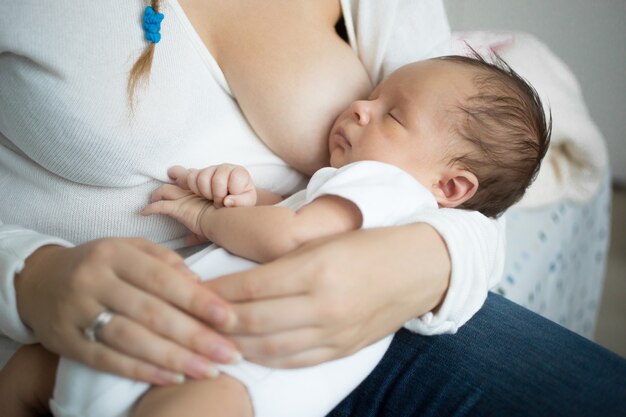 bebê fofo dormindo nas mãos da mãe depois de comer leite