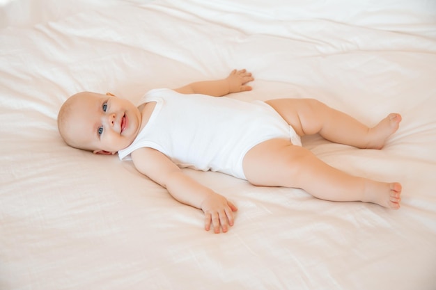 Bebê fofo está deitado na cama no quarto sorrindo