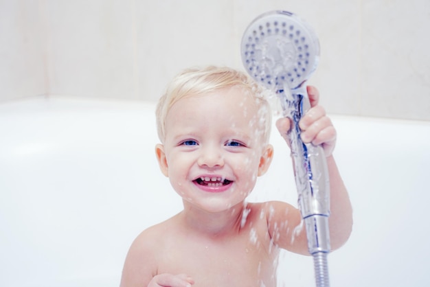 Foto bebê fofo está lavando o cabelo no banho conceito de saúde e rotina diária bebê com uma toalha depois de tomar banho banho infantil