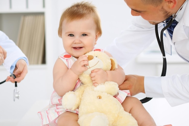 Bebê fofo feliz no exame de saúde no consultório médico Conceito de medicina e cuidados de saúde