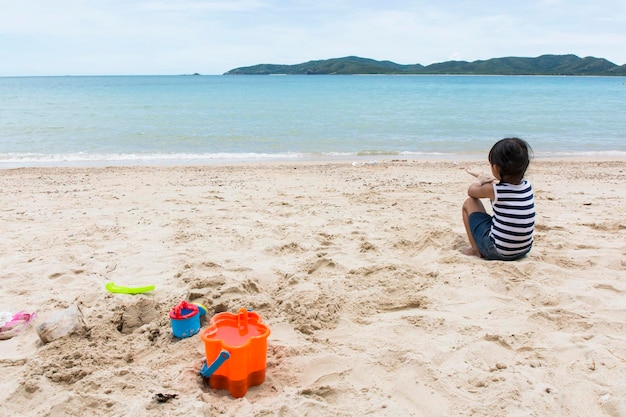 Bebê fofo menina brincando com brinquedos de praia