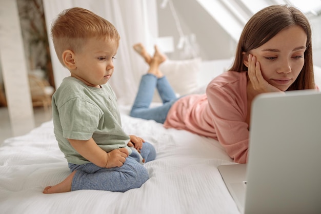 Bebê fofo olhando para a tela do laptop em casa