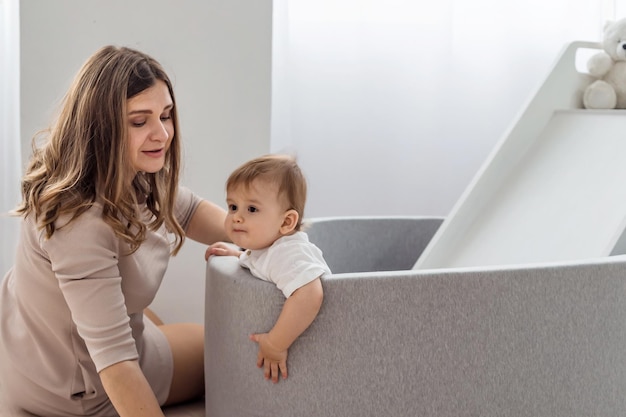 Bebê fofo passar tempo junto com a mãe no quarto das crianças