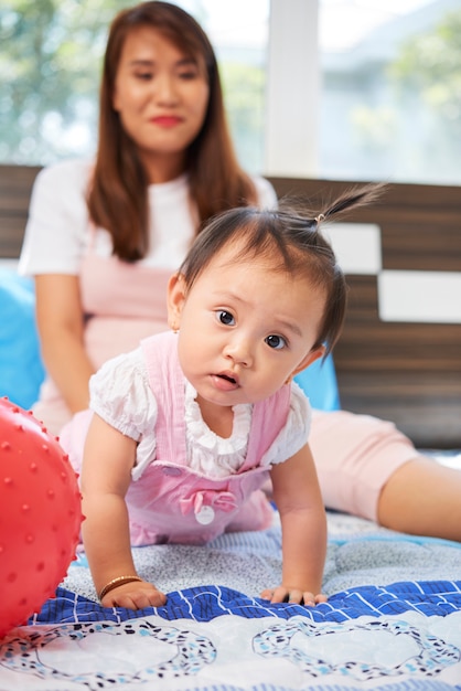 Bebê fofo rastejando na cama