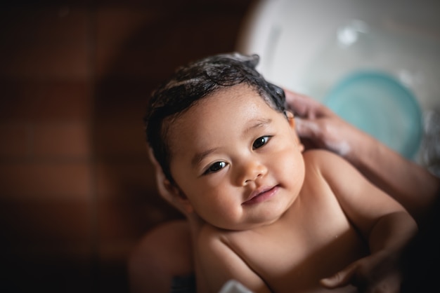 Bebê fofo tomando banho com a mãe dela