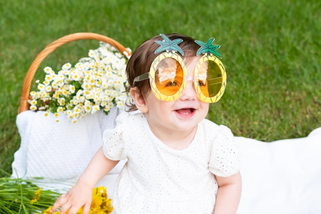 Un bebé con gafas con un lazo amarillo y un lazo verde.