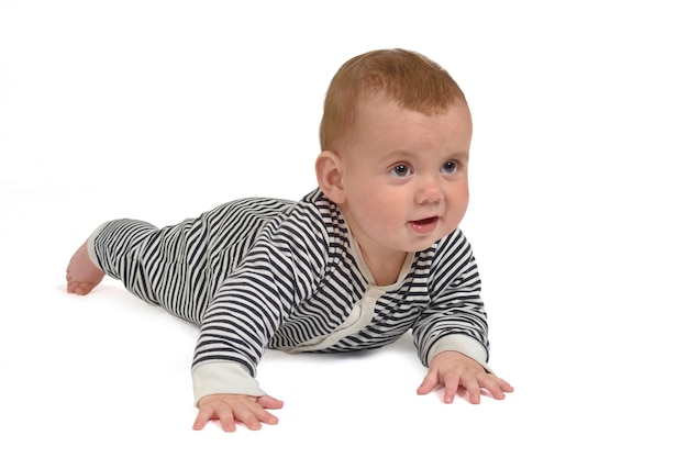 Bebé gateando por el suelo mirando hacia adelante sobre fondo blanco.