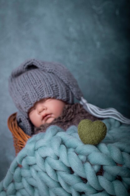 Bebé con gorro durmiendo en la cama fondo azul Amor del bebé Corazón verde