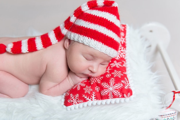 Bebé recién nacido niña vistiendo gorro blanco tejido durmiendo en