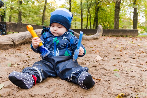 Bebé jugando en la arena en otoño