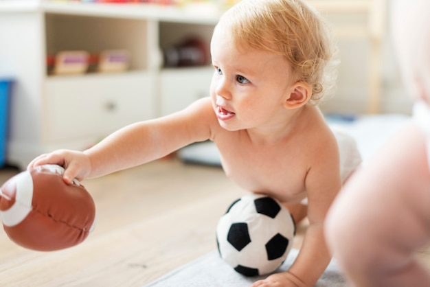 Bebé jugando con pelotas deportivas