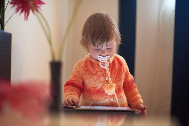 bebé jugando con una tableta en casa