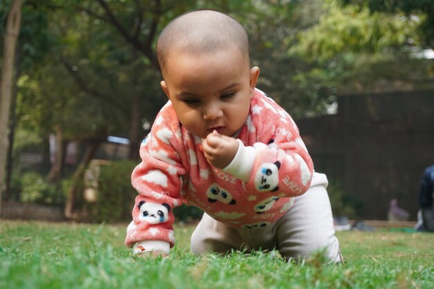 Un bebé lindo jugando afuera en el campo.