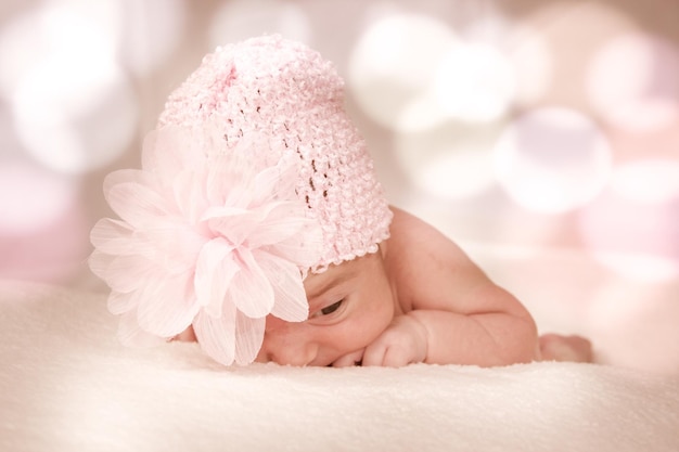 El bebé lleva un sombrero de punto rosa.