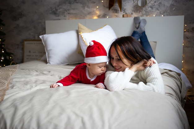 Bebé y madre en casa decorada de Navidad