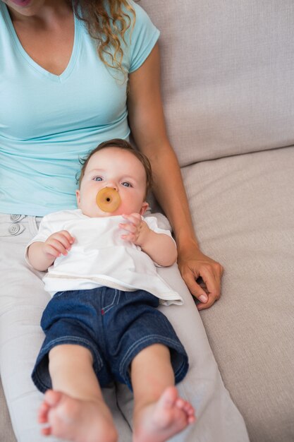 Foto bebé con la madre sentada en el sofá