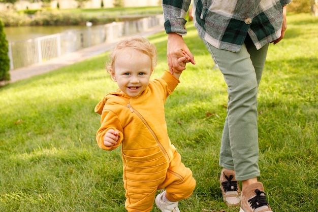 Bebé con mamá a dar un paseo por el parque en otoño