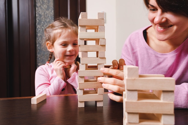 Bebé con mamá jugando en bloques de madera