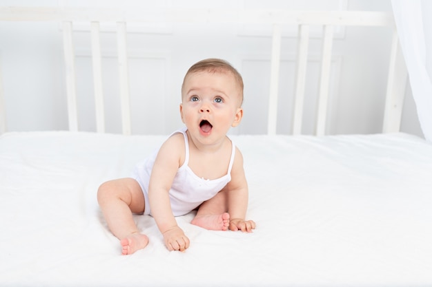 Bebê menina bonitinha sentada na cama