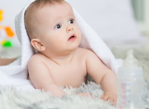 Bebé menino a engatinhar com uma toalha