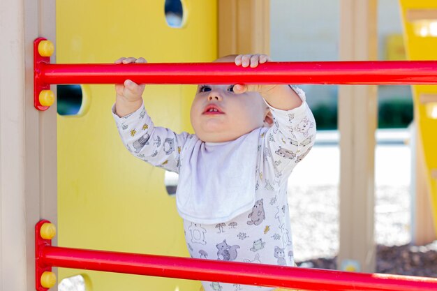 Bebê menino bonitinho brincando no parque infantil. caminhando com criança ao ar livre