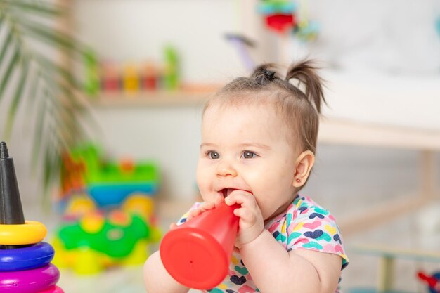 El bebé mordisquea los juguetes que el niño juega en casa en la guardería Juguetes para niños pequeños