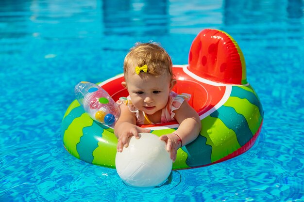 El bebé nada en círculo en la piscina. Enfoque selectivo. Niño.