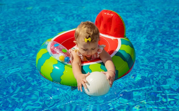 El bebé nada en círculo en la piscina. Enfoque selectivo. Niño.